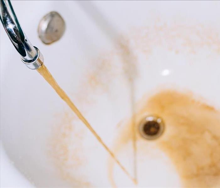 Rusty water flows from the tap into the bathtub