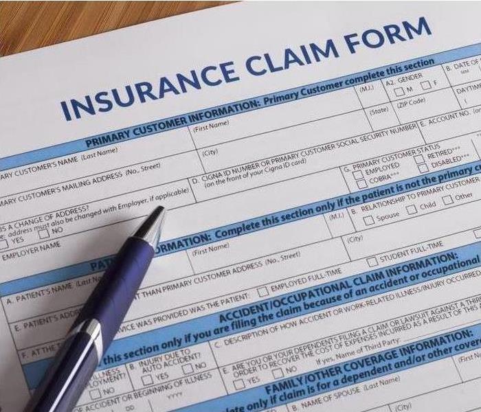 Insurance claim form and a pen laying on the table.